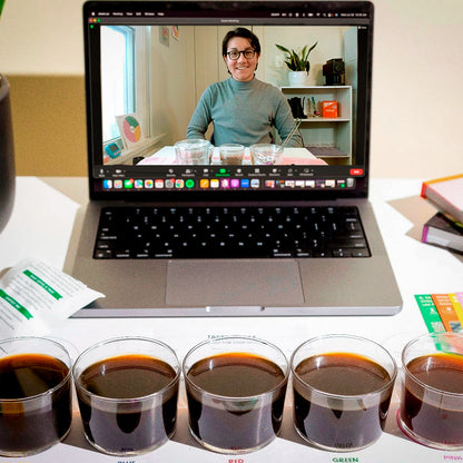 Laptop displaying a virtual tasting video call with five small cups of coffee on a table 